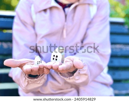 Front view of an elderly woman holding two household items Royalty-Free Stock Photo #2405914829