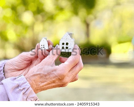 Elderly woman holding two household items Royalty-Free Stock Photo #2405915343
