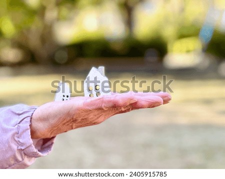 Elderly woman carrying two household items Royalty-Free Stock Photo #2405915785