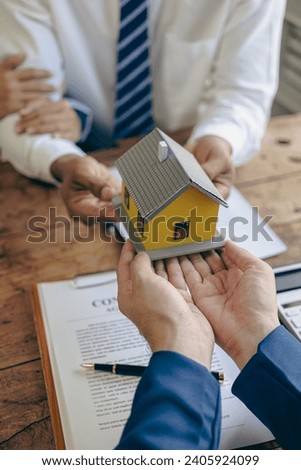 Employee or real estate agent Deliver sample homes to customers mortgage loan contract Make a contract to buy and sell a house. and home insurance contract, close-up photo