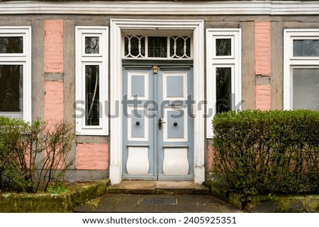 facade of a historic pink painted half-timbered house in Celle (Germany) with wooden entrance door Royalty-Free Stock Photo #2405925351