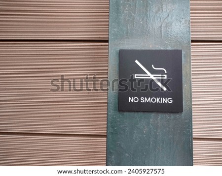 no smoking sign installed on the iron plate wall with horizontal lines pattern wall tiles