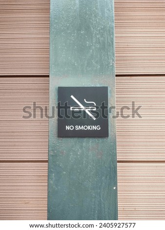 no smoking sign installed on the iron plate wall with horizontal lines pattern wall tiles