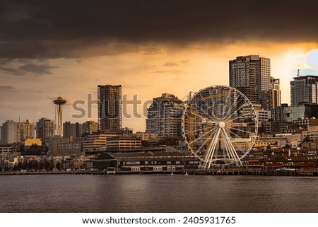VIEW OF THE DOWNTOWN SEATTLE SKYLINE FROM ELLIOTT BAY SHOWING THE WATERFRONT WITH THE GREAT WHEEL AND THE SPACE NEEDLE AND A LIGHTLY CLOUDED SKY