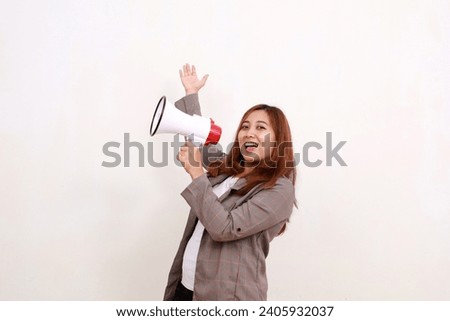 Asian businesswoman standing while holding a megaphone and presenting sideways. Isolated on white