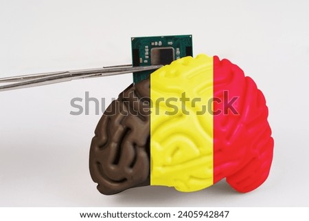 On a white background, a model of the brain with a picture of a flag - Belgium, a microcircuit, a processor, is implanted into it. Close-up