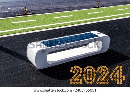 smart bench with solar panels on the bike path with 2024 Happy New Year made from golden chain links Royalty-Free Stock Photo #2405955051