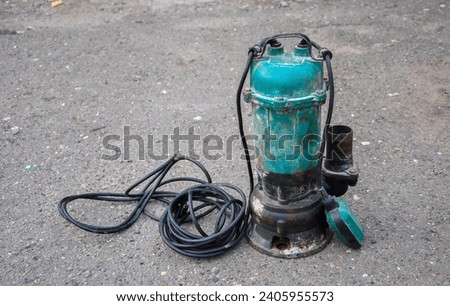 old submersible sewage pump on the ground. an old submersible pump pulled out of a drainage hole. Royalty-Free Stock Photo #2405955573