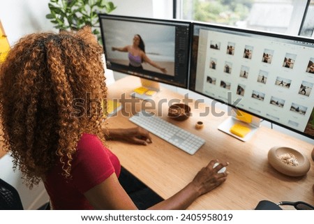 Creative agency employee retouching digital photos while using computer mouse and display