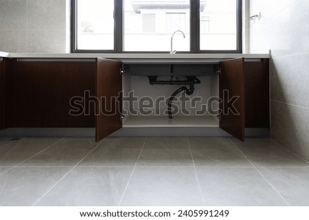 Open the cabinet under the sink Royalty-Free Stock Photo #2405991249