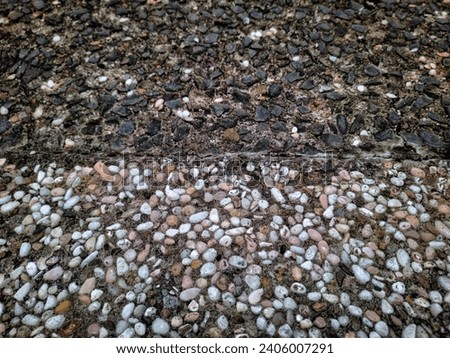 Smooth round pebbles texture background. Pebble sea beach close up, dark wet pebbles and white dry pebbles of house yard. High quality photos