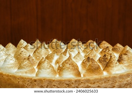 Close-up of lemon meringue tart in wooden background, selective focus