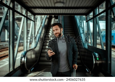 Stylish Businessman with Smartphone at Train Station Royalty-Free Stock Photo #2406027635