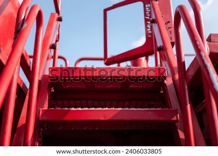 Close-up at metal steps part  with anti-slip floor and caution sign of the working platform stairway. Industrial equipment object photo, selective focus. Royalty-Free Stock Photo #2406033805