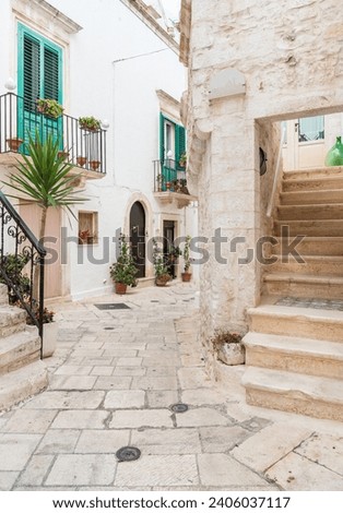 Characteristic narrow streets in the Locorotondo, metropolitan city of Bari, in Puglia, Italy Royalty-Free Stock Photo #2406037117