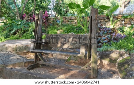 Location photos A wooden swing bench with a backrest sits under the shade in the middle of a stone-paved garden. Surrounded by a natural atmosphere, relaxing during the day, clear weather, various typ