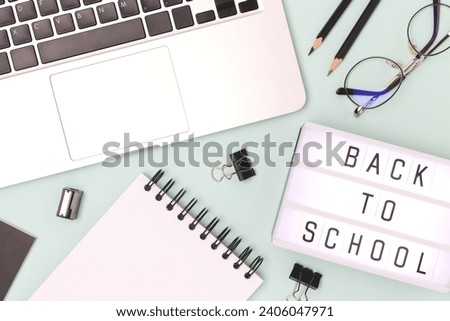 Back to school. Lightbox, eyeglasses, laptop and stationery on a blue background. Workspace for e-learning.