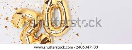 Banner with number 20 gold colored balloons with stars confetti on a blue background. Place for text. Royalty-Free Stock Photo #2406047983