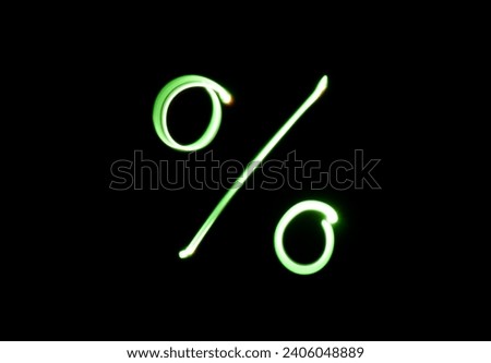 A photograph of a percentage symbol in vibrant green light in a long exposure photo against a black background. Light painting photography