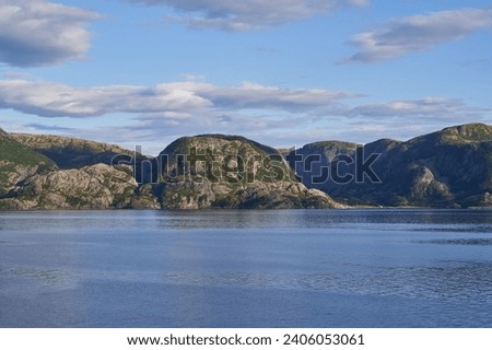 Landscape picture of the dramatic and wild coast of the Norwegian sea in the north Norway. Beautiful example of clean arctic style nature without people. Picture is taken in sunny summer evening.
