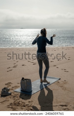 Young woman practicing yoga on the beach. Early morning. Healthy lifestyle.