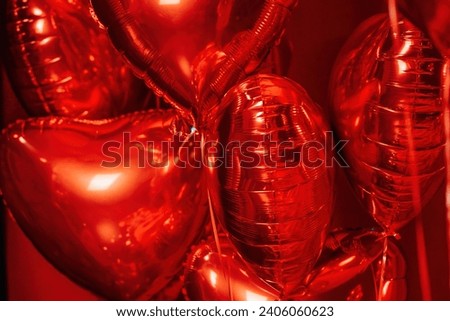 Extravagant glamour background with red foil heart air balloons for love party. Beautiful romantic burlesque room place for st valentines holiday illuminated vanity makeup mirror muffled light Royalty-Free Stock Photo #2406060623