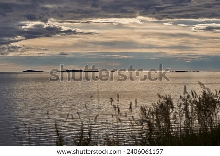 Landscape picture of the calm water, long shadows and midnight sunlight in the Norwegian fjord in arctic summer midnight. Beautiful, mystic time, silent and peaceful, ideal to think about ourselves.
