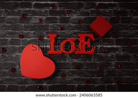 Two red heart gift box and word love tree on black brick background.