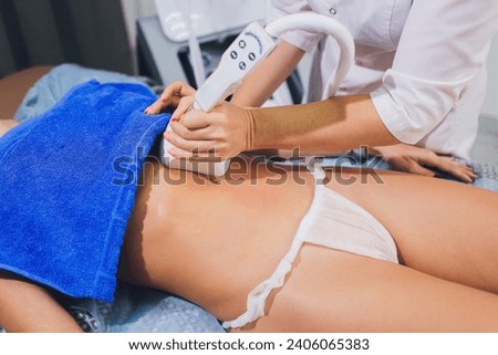 Cropped view of cosmetologist with roller doing buttocks massage