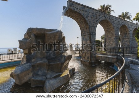 water fountain on old ruins and architicture by the beach Royalty-Free Stock Photo #2406072547