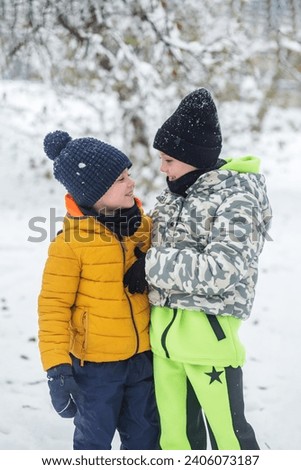 Happy children hugging outside in winter. Brother and sister together. Outdoor play. Cold temperature. Winter time