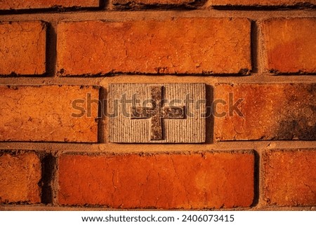 image of a christian cross in a red brick wall, procession of the cross