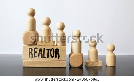 Someone hand and wooden hand together holding colored wood with word REALTOR