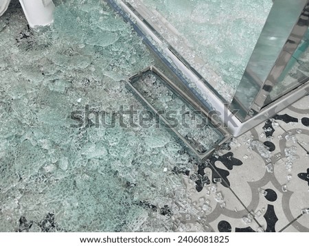 Broken glass shower door with chrome handle in a tiled bathroom Royalty-Free Stock Photo #2406081825