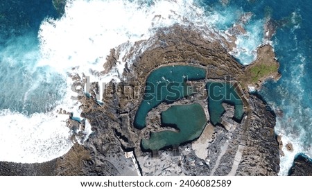 A stunning aerial view of the natural swimming pools of Las Salinas de Agaete, located in the north west of Gran Canaria, Spain. The pools are formed  Royalty-Free Stock Photo #2406082589
