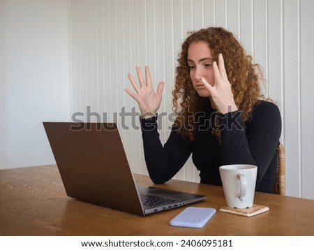 Side view of a red hair young woman frustrated because of working from home while having a cup of tea