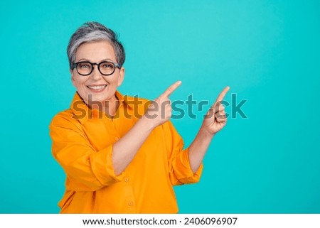 Photo of charming old woman point fingers billboard information technologies progress presentation isolated on aquamarine color background