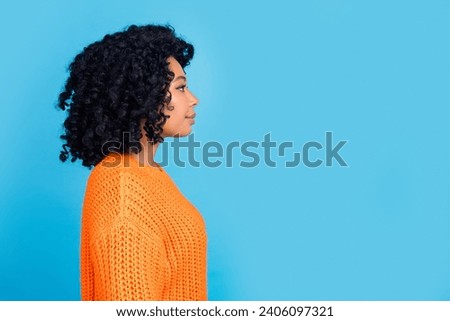 Photo portrait of pretty young girl profile look empty space dressed stylish knitted orange outfit isolated on blue color background