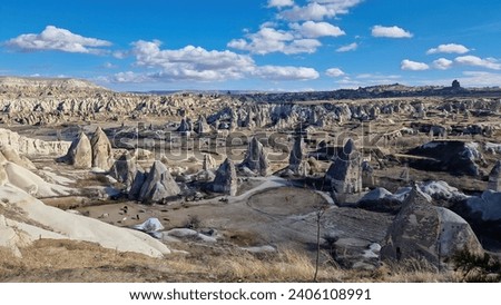 From the mountain's vantage point, Cappadocia unveils its pastoral heart: sprawling farms, patchwork fields, and the age-old rhythms of agrarian life echoing through time. Royalty-Free Stock Photo #2406108991