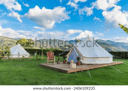 Two glamping sites on a sunny day with a beautiful mountain landscape in the background and a spectacular blue sky. Glamorous Camping Royalty-Free Stock Photo #2406109235