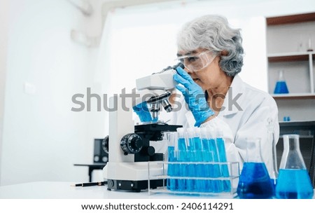 scientists conducting research investigations in a medical laboratory, a researcher in the foreground is using a microscope in laboratory for medicine.  

