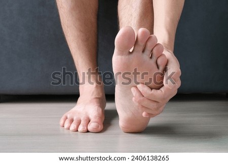 Man, foot pain and cramps in legs and ankles from Plantar Fasciitis disease Be relieved the pain with the soles of his feet. Royalty-Free Stock Photo #2406138265