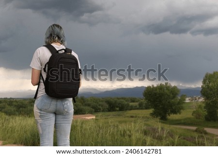 woman standing with her back turned looking at the mountain range in Colorado