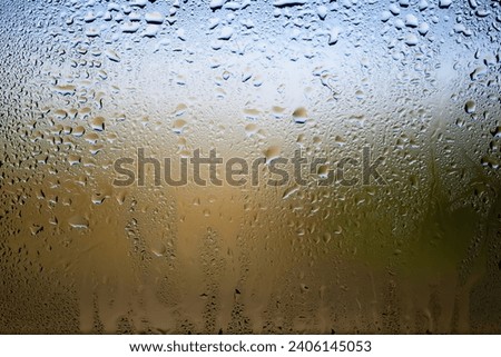 Drops of rain on the window. Water drops on glass. Abstract background. Green natural landscape. Texture of drops. Soft focus