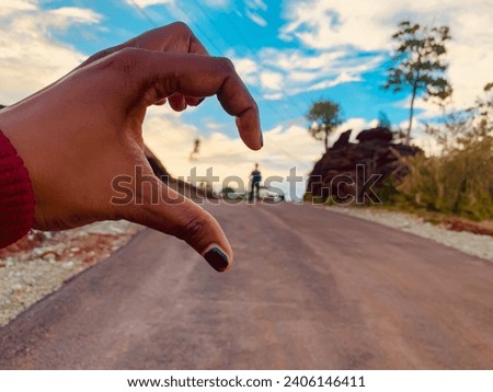 Half-hearted hands. The picture shows a beautiful sunset with the sky in the background and a person waiting with half his heart