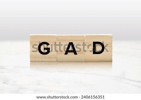 Light wooden tiles spelling out GAD atop an elegant marble background with a reflection. Generalized anxiety disorder mental health concept. Royalty-Free Stock Photo #2406156351