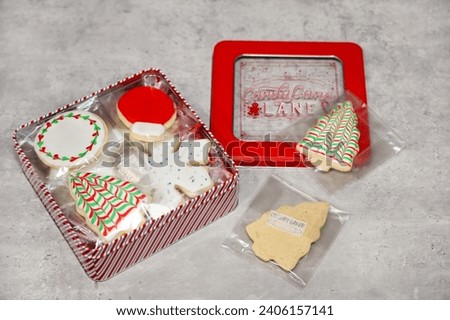 Homemade sugar cookies individually wrapped and packaged in a window tin box for gifting. Small business concept.