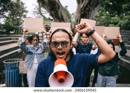 Man with raised fist shouting through megaphone, human rights or justice with freedom of speech.