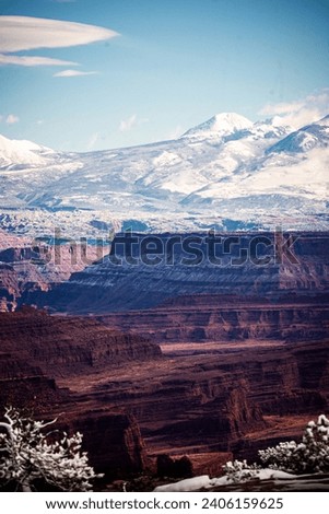 dramatic view of La Sal mountain range and red sandstone canyons and formations
