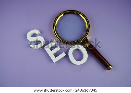 SEO letters and magnifying glass top view on purple background